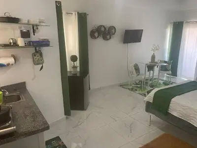 a room with a bed and a table in it at Royal Terrace Queen 1 in San Felipe de Puerto Plata