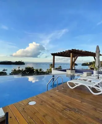 a villa with a infinity pool and a wooden deck at Beautiful Apartment overlooking Samaná Bay