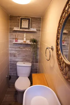 a bathroom with a toilet and a mirror at La casa del lago in Cumayasa