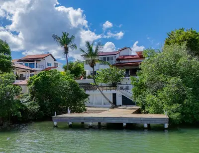 a house on the water with a dock at La casa del lago in Cumayasa