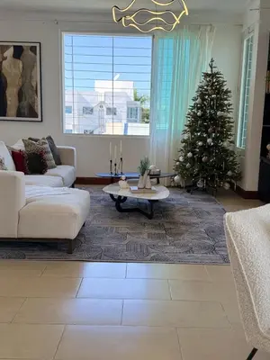 a living room with a christmas tree and a couch at Moderno y Acogedor Apartamento detrás del Homs in Santiago de los Caballeros