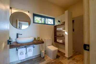 a bathroom with a sink and a toilet and a mirror at Villa Libelula, Ocean View, Private Pool,3 Suites in El Limón
