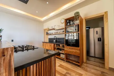 a kitchen with a counter and a refrigerator at Villa Libelula, Ocean View, Private Pool,3 Suites in El Limón