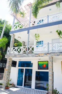 a white building with a tv in front of it at Batey Hotel Boutique in Boca Chica