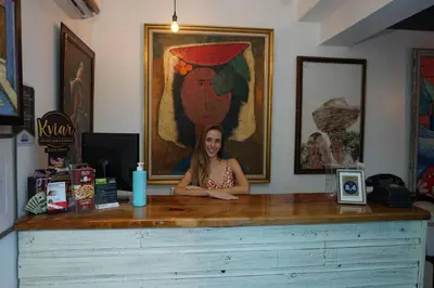 a woman sitting at a counter in a room at Batey Hotel Boutique in Boca Chica