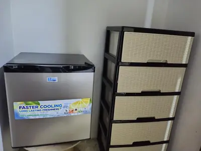 a refrigerator sitting next to a stack of shelves at Double bed room in Santo Domingo