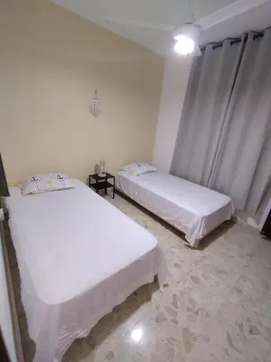 two beds in a room with white sheets at Double bed room in Santo Domingo