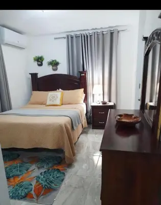 a bedroom with a bed and a table in a room at Cozy Romance Apartment-Couples Only in Santiago de los Caballeros