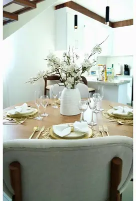 a dining room table with a vase of flowers on it at Luxurious 3-Bedroom Retreat in Santiago de los Caballeros in Santiago de los Caballeros