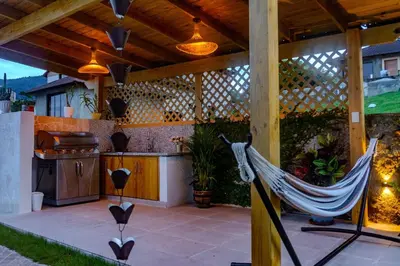 a hammock on a patio with a kitchen at Our dreams house in Jarabacoa