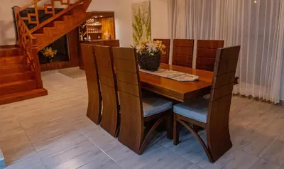a wooden dining room table with chairs and a staircase at Our dreams house in Jarabacoa