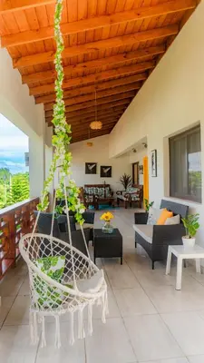 a porch with a hammock and a living room at Our dreams house in Jarabacoa