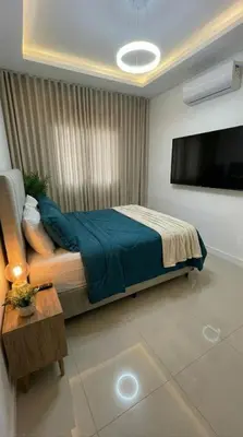 a bedroom with a bed and a flat screen tv at Apartamento paseo del bosque in Santo Domingo