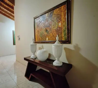 a table with two vases and a painting on the wall at Aura Azul in Sosua