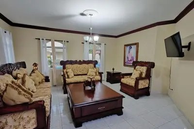 a living room with a couch and a table and chairs at Aura Azul in Sosua