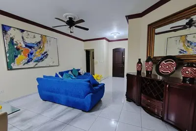 a blue couch in a living room with a ceiling fan at Aura Azul in Sosua