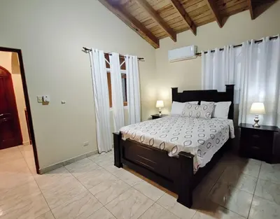 a bedroom with a large bed with two lamps on tables at Aura Azul in Sosua