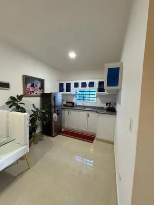 a kitchen with white cabinets and a counter top at Cruzairbnb in San Felipe de Puerto Plata