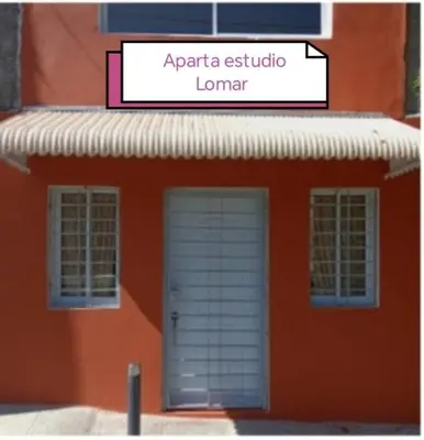 a orange building with a door and a sign on it at Aparta estudio Lomar II in Puerto Plata