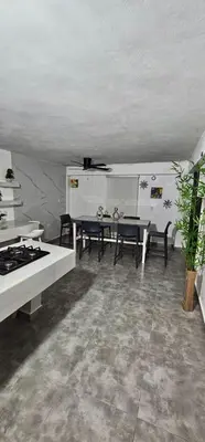 a living room with a table and chairs and a stove at Coco house by Julio in Nagua