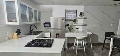 a kitchen with a stove top and a refrigerator at Coco house by Julio in Nagua