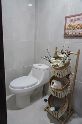 a bathroom with a toilet and two baskets at Cozy Loft In The Heart of Santo Domingo Este in Juan López