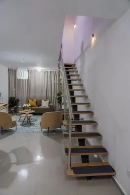 a spiral staircase in a living room with a couch at Cozy Loft In The Heart of Santo Domingo Este in Juan López