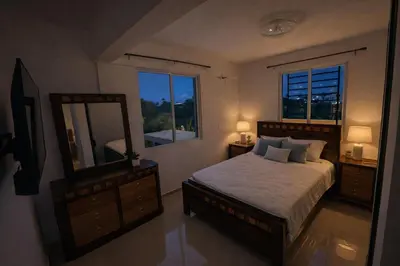 a bedroom with a large bed and a mirror at Private residential vacation home in Cabarete in Cruce de Veragua