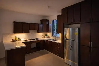 a kitchen with wooden cabinets and a stainless steel refrigerator at Private residential vacation home in Cabarete in Cruce de Veragua