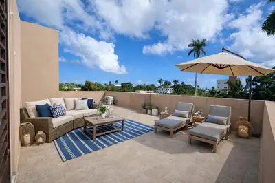 a patio with a couch and chairs and an umbrella at Private residential vacation home in Cabarete in Cruce de Veragua
