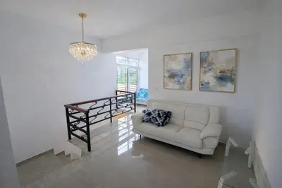a living room with a white couch and a chandelier at Private residential vacation home in Cabarete in Cruce de Veragua