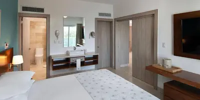 a bedroom with a bed and a sink and a mirror at Imperial Suite 1-bedroom ocean view and kitchen in Cabarete