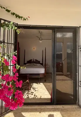 a bedroom with a bed through a sliding glass door at Villa Aurora Samaná in Santa Bárbara de Samaná