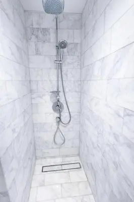 a bathroom with a shower with white tiles at Villa Wolf in Punta Cana
