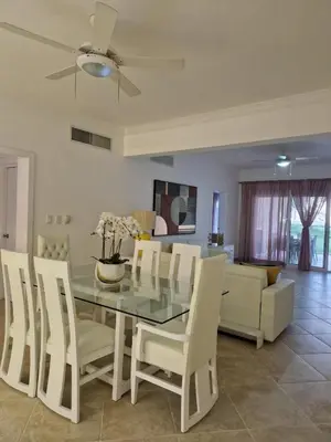 a dining room with a glass table and white chairs at Big & classy condo at Cocotal Golf & Beach in Punta Cana
