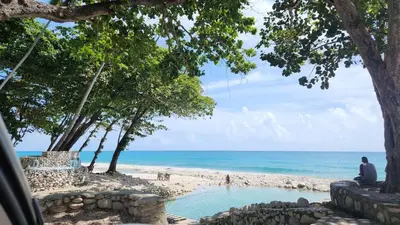 a man sitting on the beach looking at the ocean at 2 Bdrm 1 Bath Near River and Beach, 3L, Paraiso, Barahona in Paraíso