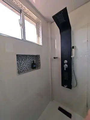 a bathroom with a shower with a black object on the wall at 2 Bdrm, 1 Bath, Wifi, Near River and Beach, 3R, Paraiso, Barahona in Paraíso