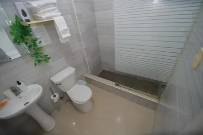 a white bathroom with a toilet and a sink at franchecis hostal cerca del mar in Juan Dolio