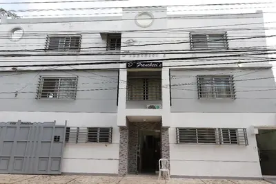 a white building with windows and a door at franchecis hostal cerca del mar in Juan Dolio