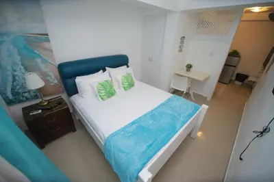 a bedroom with a large bed with a blue headboard at Arena blanca Franchecis hostal in Juan Dolio