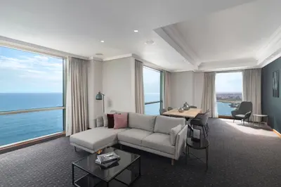 a living room with a couch and a desk and windows at Catalonia Santo Domingo in Santo Domingo