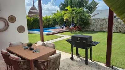a barbecue in a backyard with a table and chairs at Wohlfühloase in der Karibik in Punta Cana