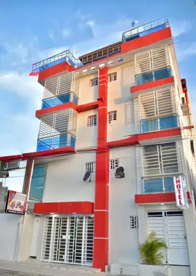 a tall white and red building with windows at Hotel la playa in Santa Cruz de Barahona