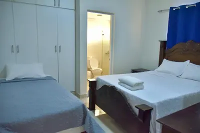 a bedroom with two beds and a bathroom with a toilet at Hotel la playa in Santa Cruz de Barahona