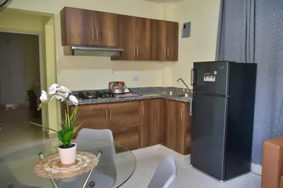 a kitchen with a glass table and a black refrigerator at Hotel la playa in Santa Cruz de Barahona