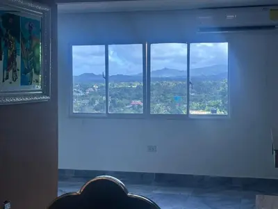 a room with three windows with a view of a city at Comodidad, descanso y una vista que inspira in Miches