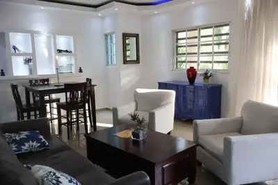 a living room with a couch and a table at Cozy apartment AC, Hot Water, WiFi, Pool, Bar, Bani 203 in Baní