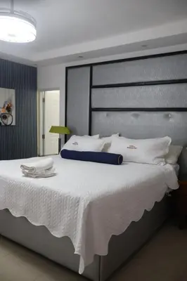 a bedroom with a large bed with white pillows at Cozy apartment AC, Hot Water, WiFi, Pool, Bar, Bani 203 in Baní