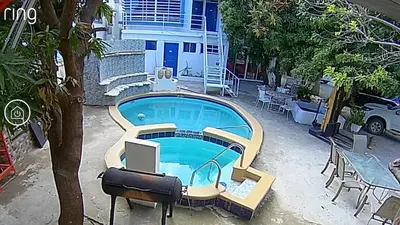 a swimming pool with a tv in front of a house at Cozy apartment AC, Hot Water, WiFi, Pool, Bar, Bani 203 in Baní