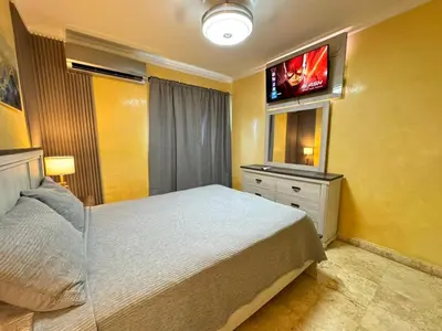 a bedroom with a bed and a tv on the wall at Dreamvillage in Boca Chica